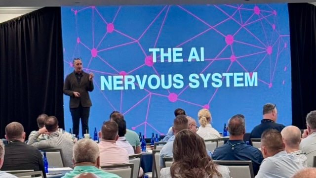 James Poulter presenting The AI Nervous System keynote on stage